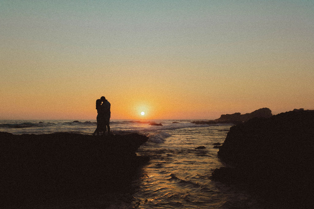 Couple silhouetted against a Pacific sunset