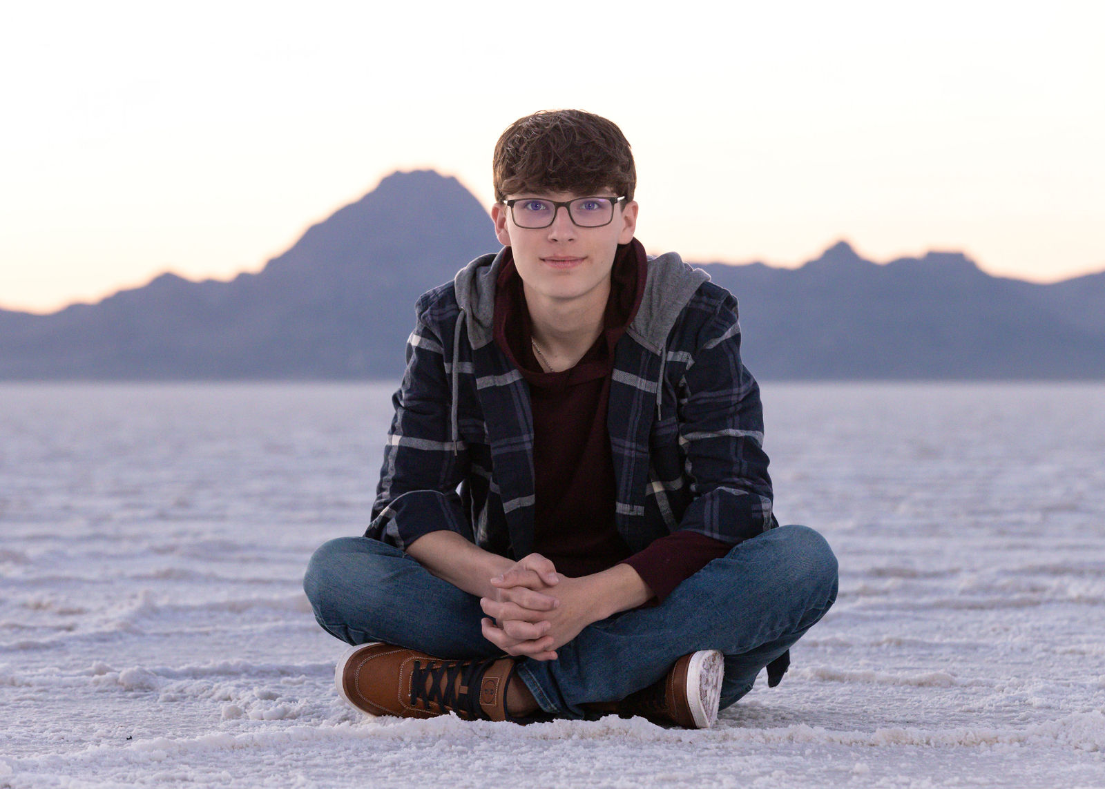 Wide shot senior portrait at Bonneville Salt Flats with minimal background and strong composition