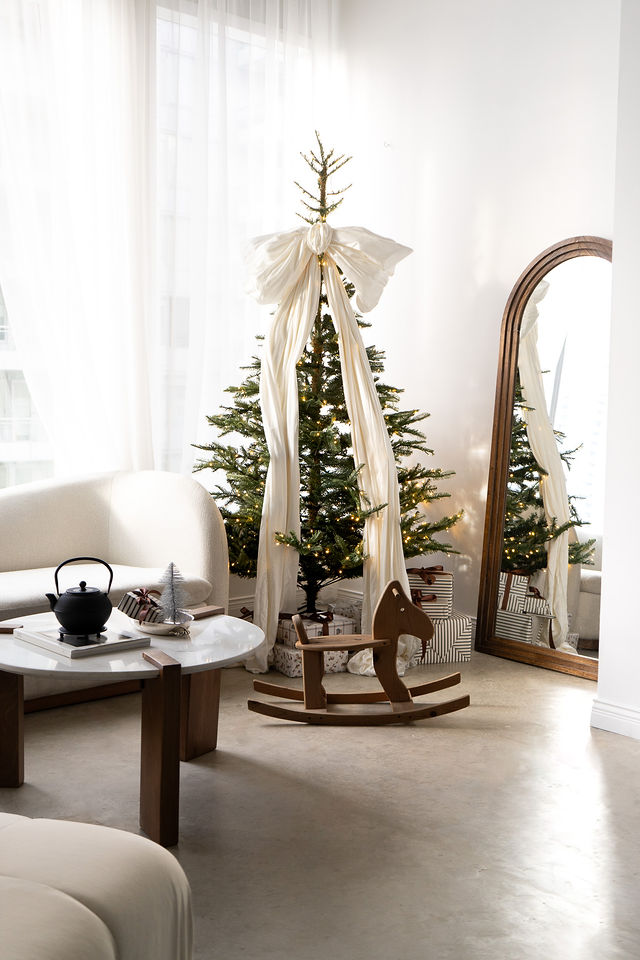Holiday studio with a Christmas tree, lounge seating and mirror