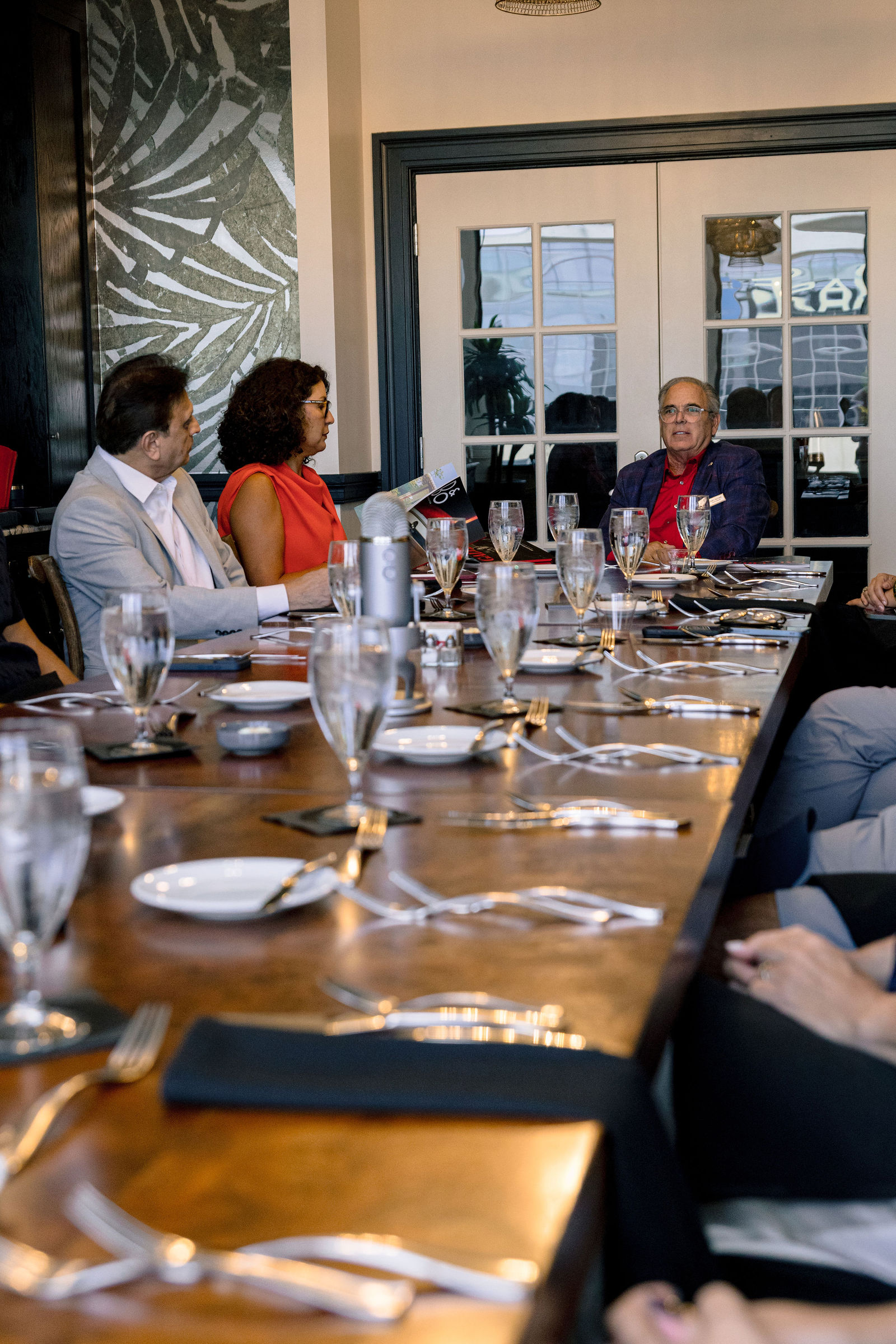 Place settings along the table, the curators in conversation beyond them.