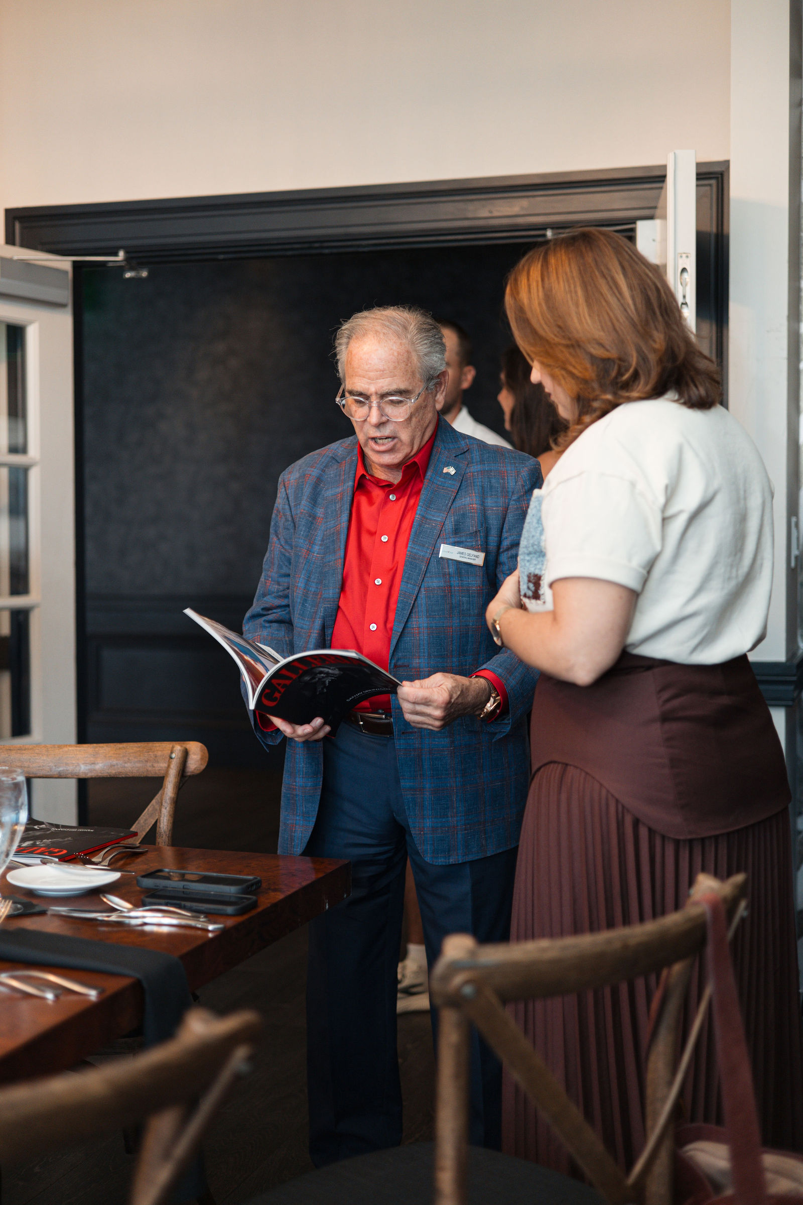 James Gelfand reading the first issue with a guest at the doorway of the private room.