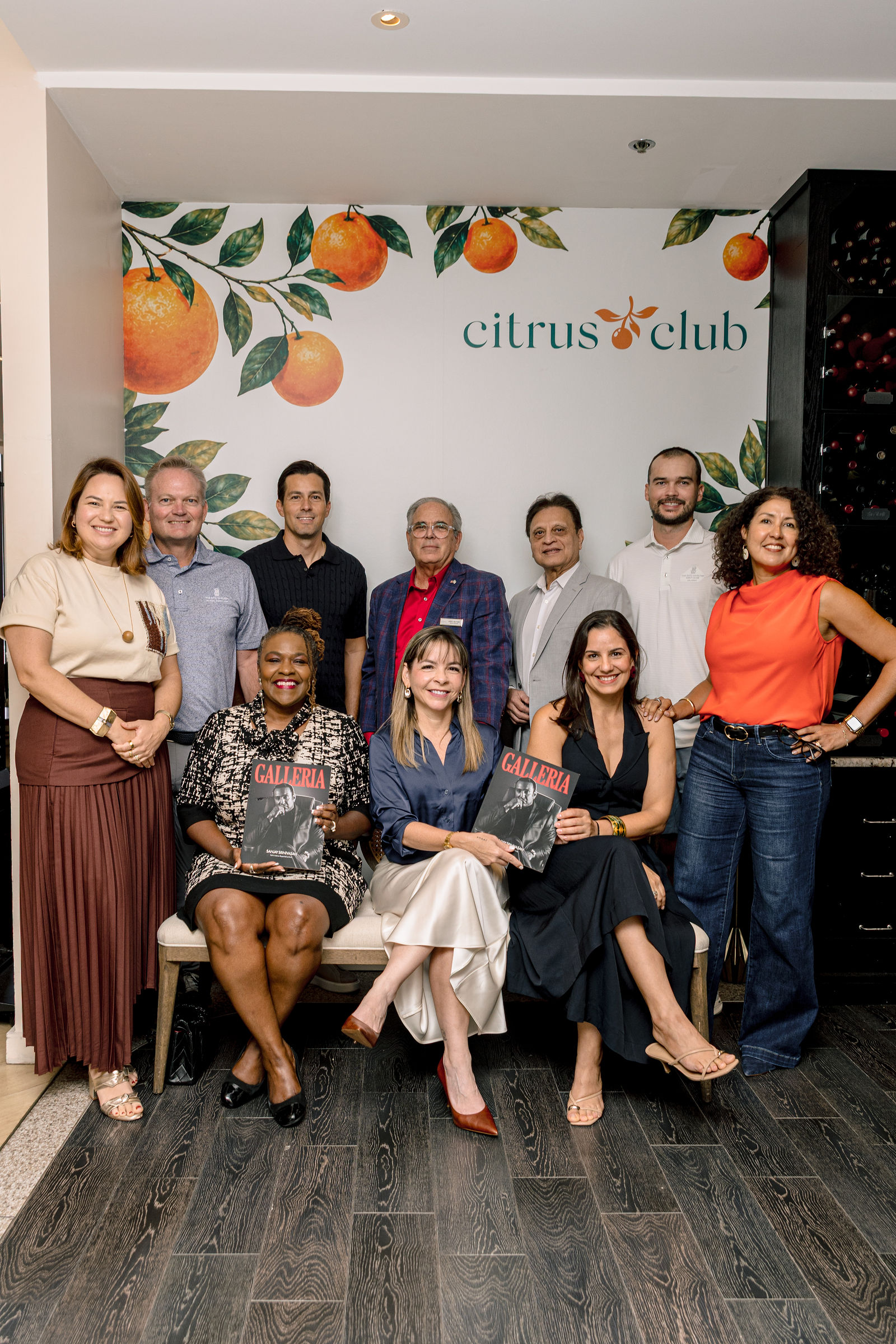 The Curator Circle with the Galleria team, gathered under the Citrus Club wall; the front row seated with copies of the first issue.