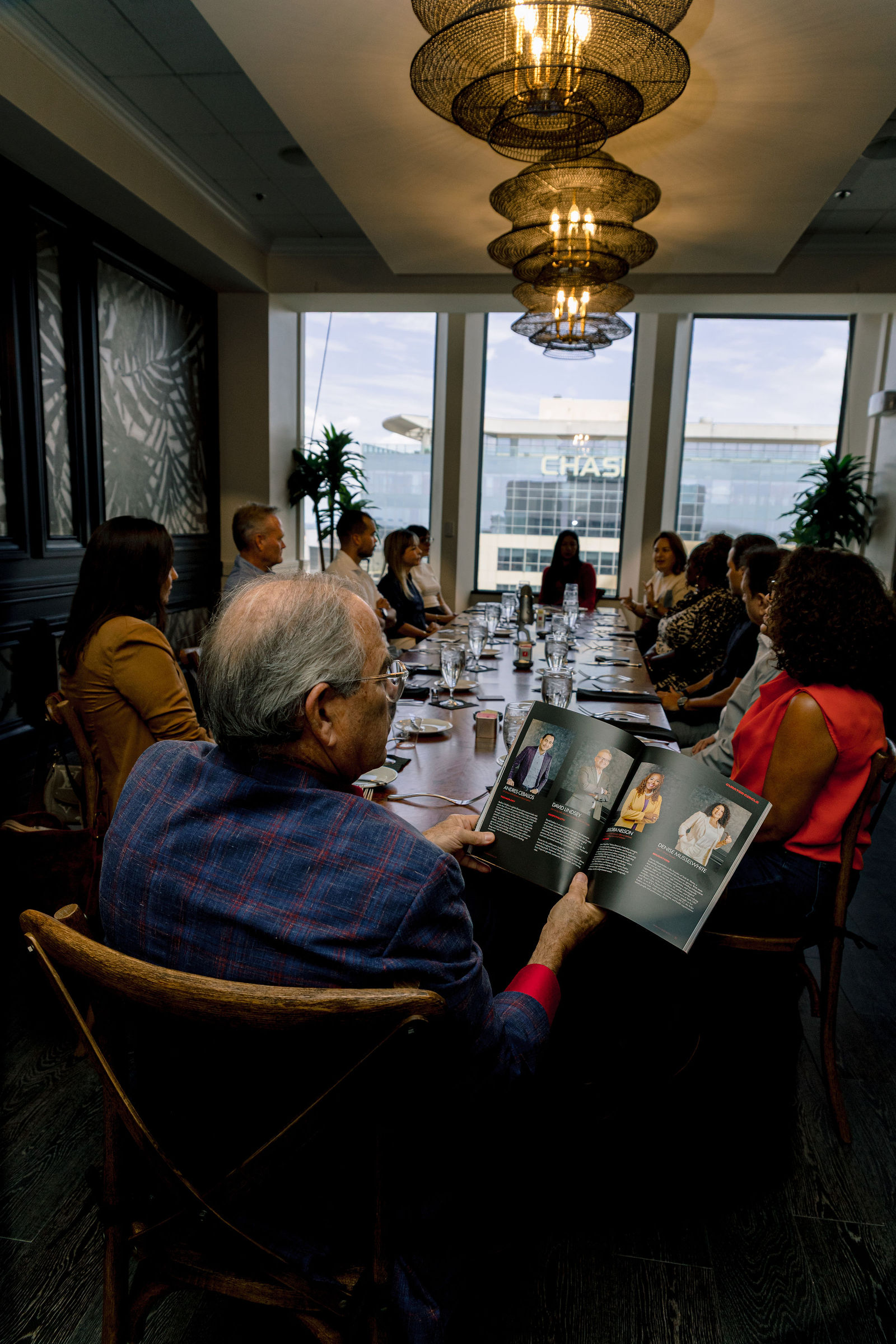 The table leafing through the first issue under the chandeliers.
