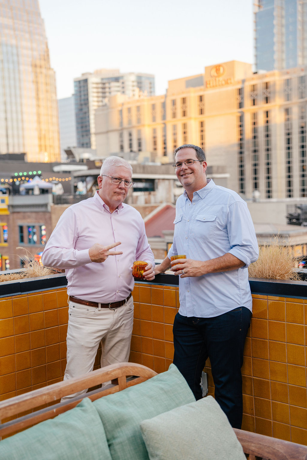 Event photography company coverage of a branded rooftop reception with neon signage in Nashville