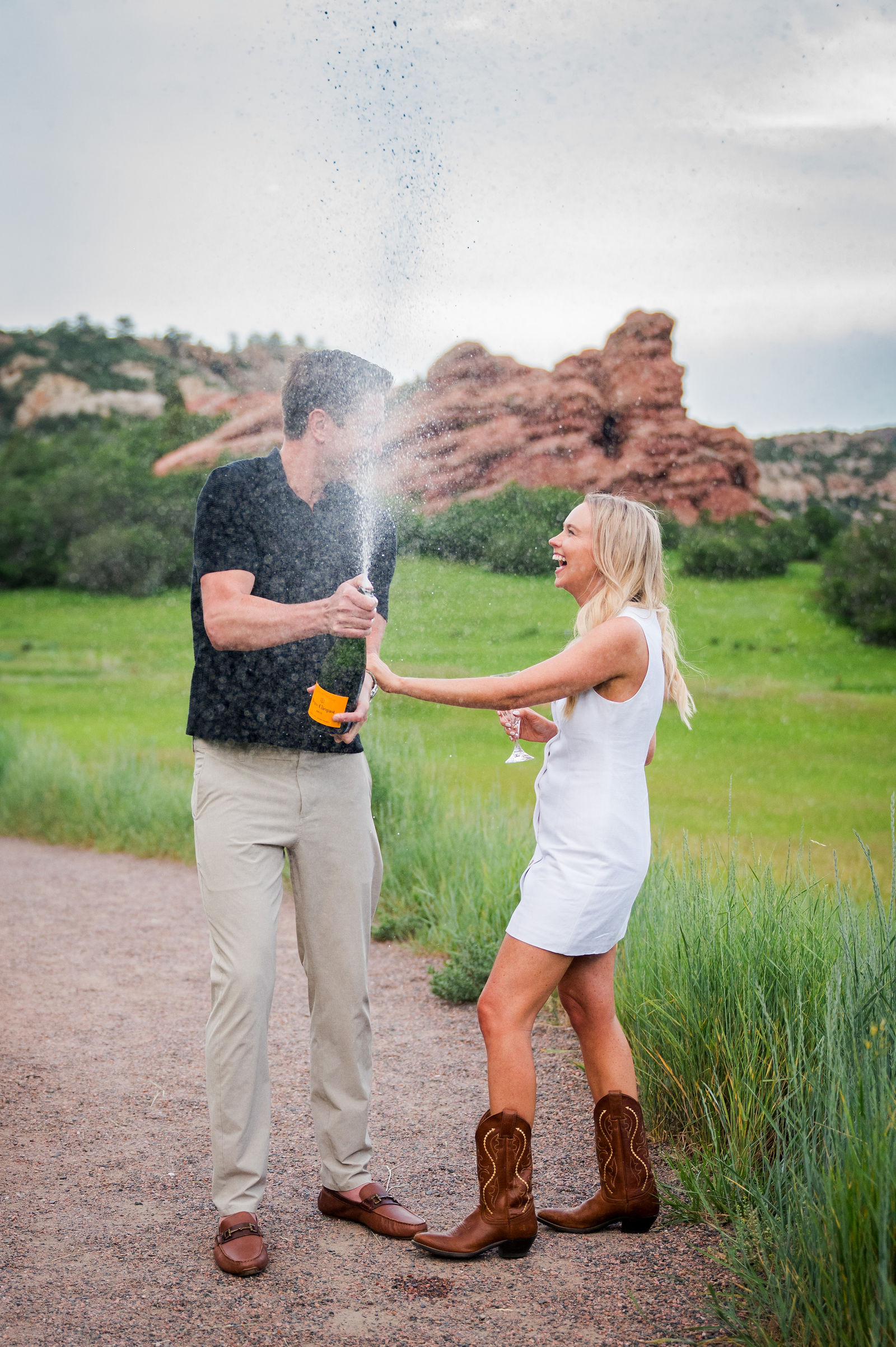 Newly engaged Colorado couple popping champagne to celebrate at Red Rocks