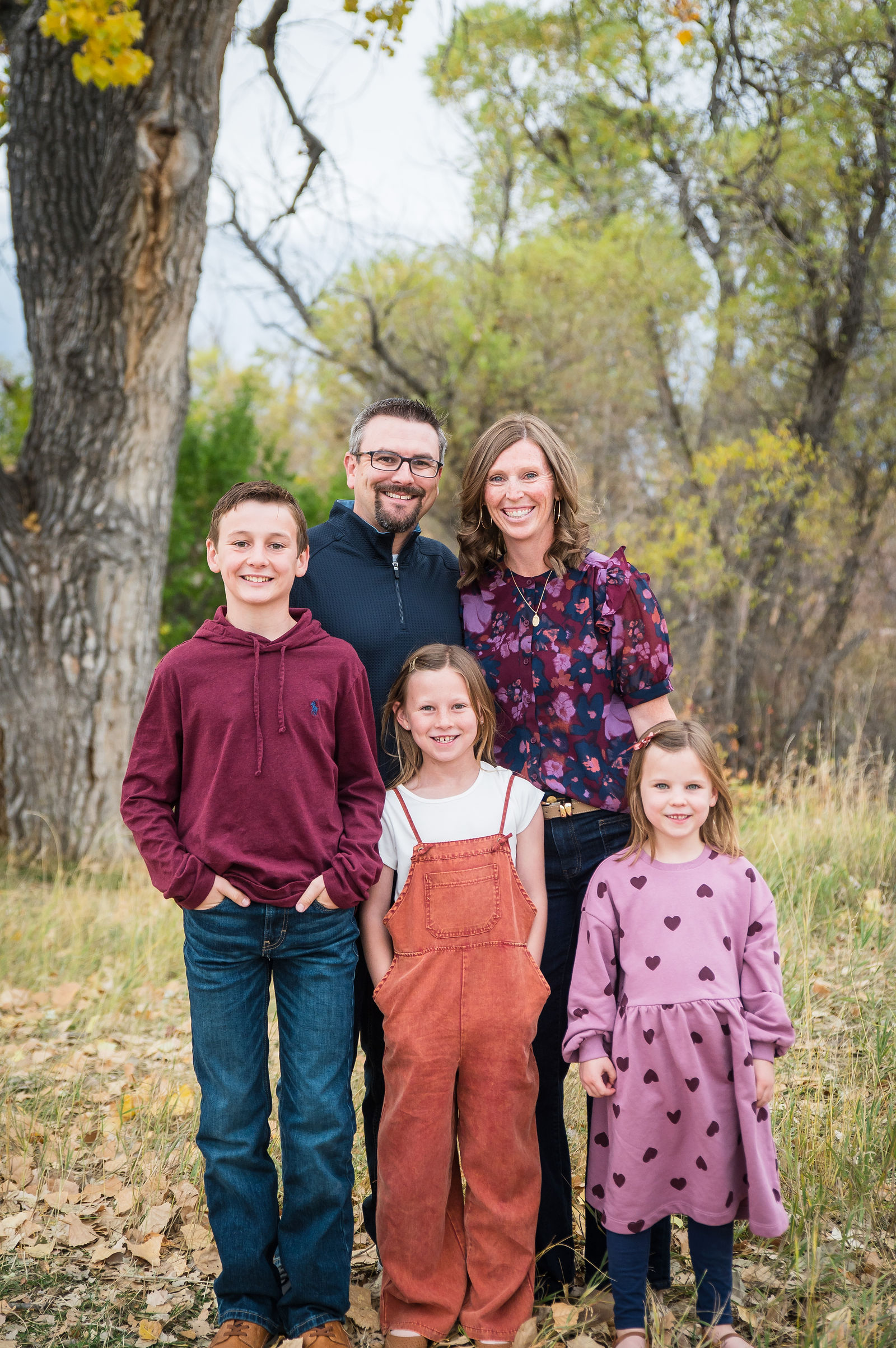 Colorado family in burgundy, rust and mauve fall outfits among yellow cottonwood trees