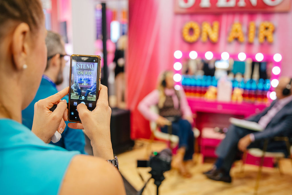 Brand video production set with branded lighting and a tripod camera at a Nashville trade show