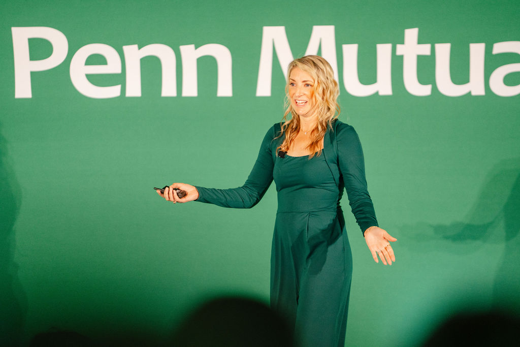 Two presenters on stage in front of a branded backdrop during a Nashville convention general session