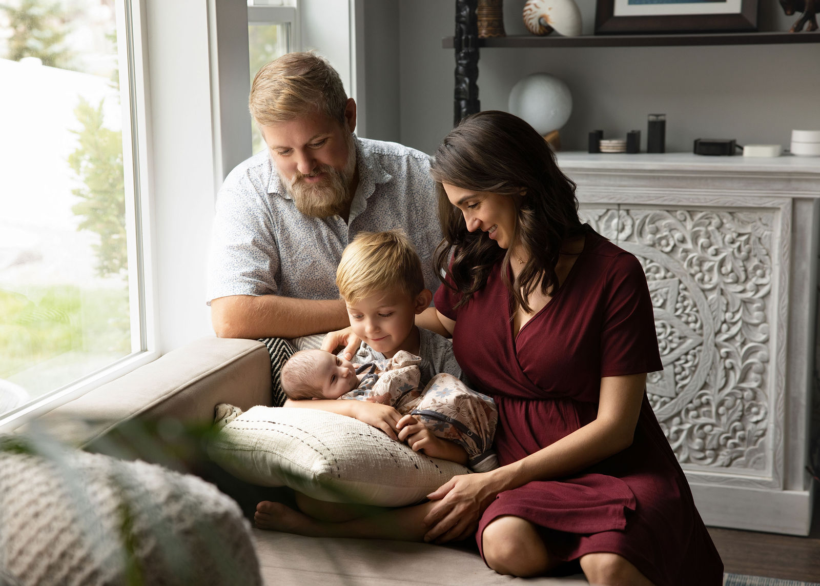 Salt Lake City in-home newborn photography with parents cuddling baby near a bright window