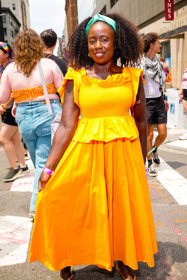 Woman in yellow smiling at NYC Pride