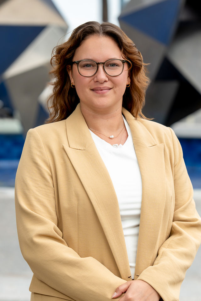 Headshot of a woman in glasses and a tan blazer, photographed by Dodi Images