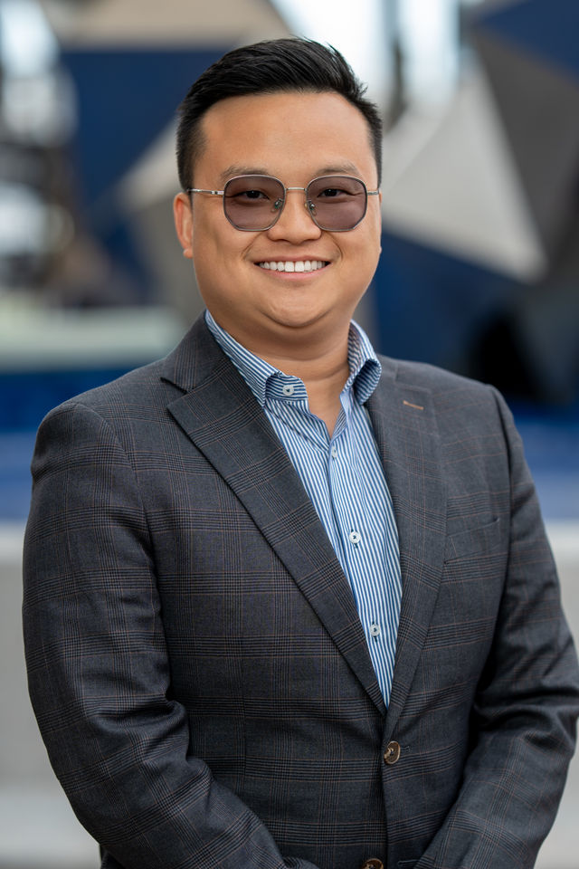Professional headshot of a man in glasses and a dark suit, photographed by Dodi Images