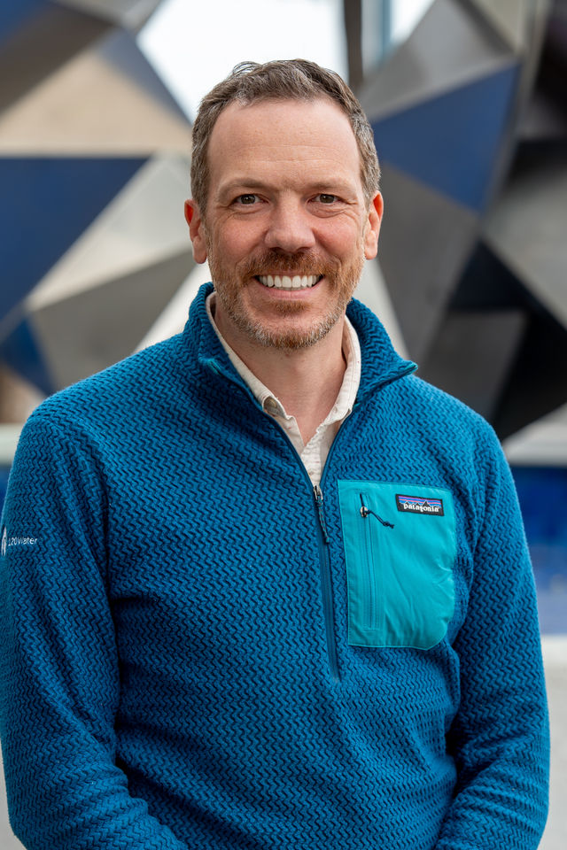Headshot of a man in a teal sweater, photographed by Dodi Images