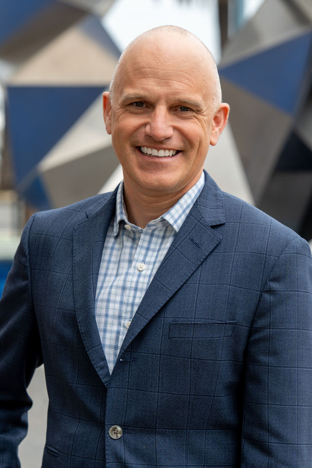 Corporate headshot of a man in a navy suit, photographed by Dodi Images