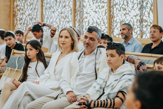 בן ומשפחתו בבית הכנסת