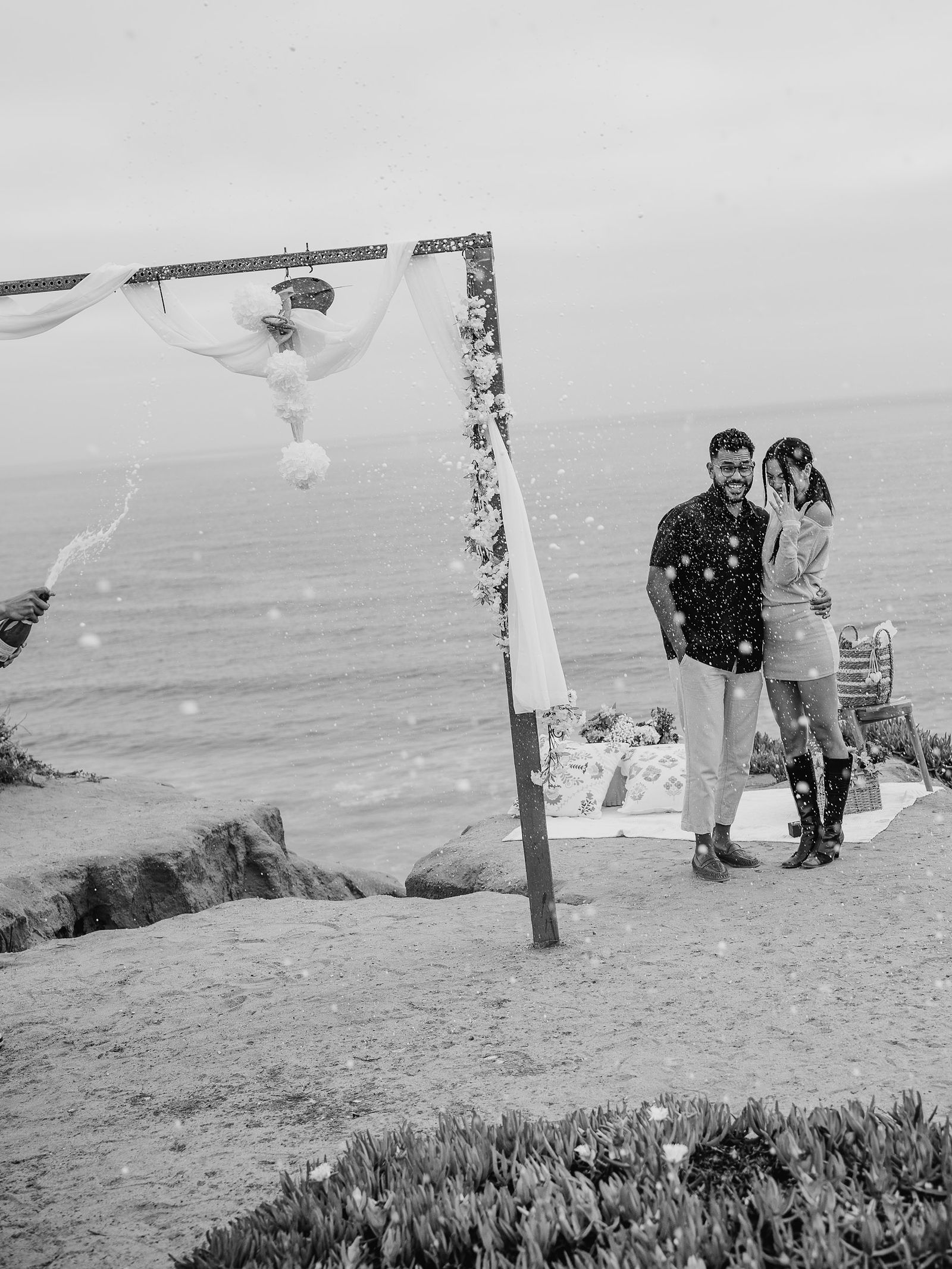A friend popping champagne after a surprise proposal in San Diego.