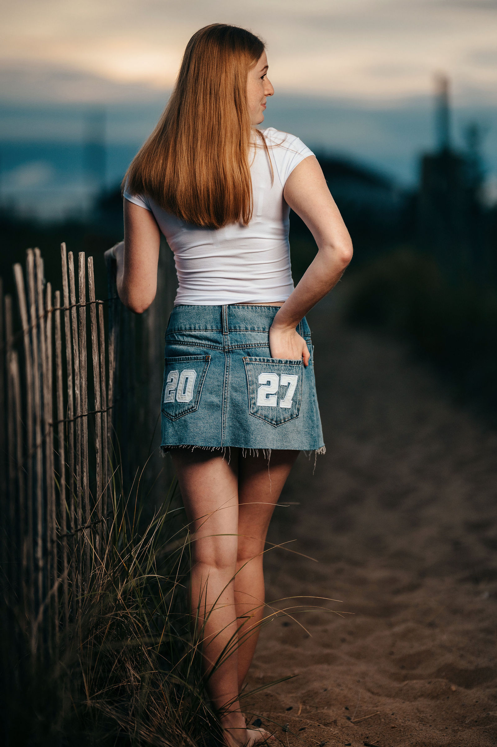 Arianna from behind wearing a denim skirt with 27 during her senior portrait session