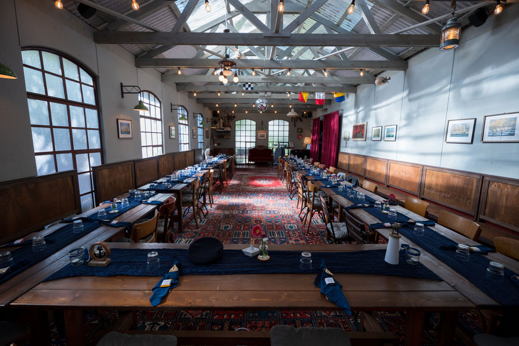 Festsaal mit Glasdach und langen Hochzeitstafeln in der Oberhafenkantine, Hochzeitslocation Berlin