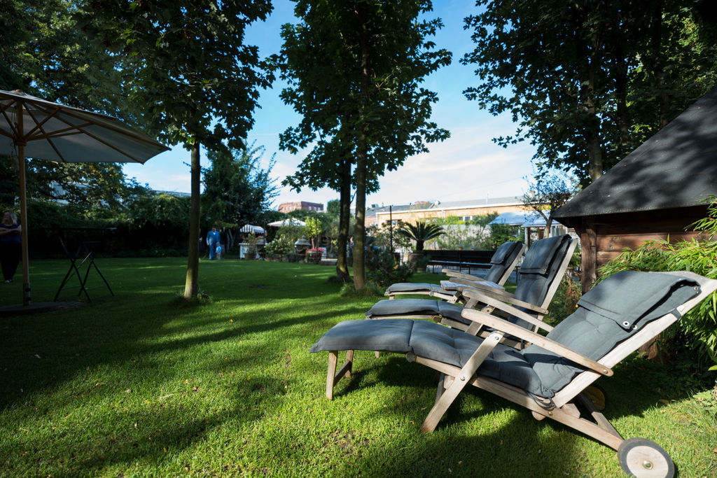 Grüner Garten mit Liegestühlen im Schatten der Bäume, Oberhafenkantine Berlin, Hochzeitsfotograf Berlin und Brandenburg