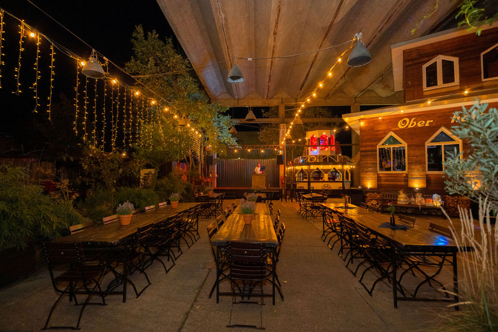 Abendstimmung mit Lichterketten und langen Tafeln in der Oberhafenkantine Berlin, Hochzeitsfotograf in Berlin