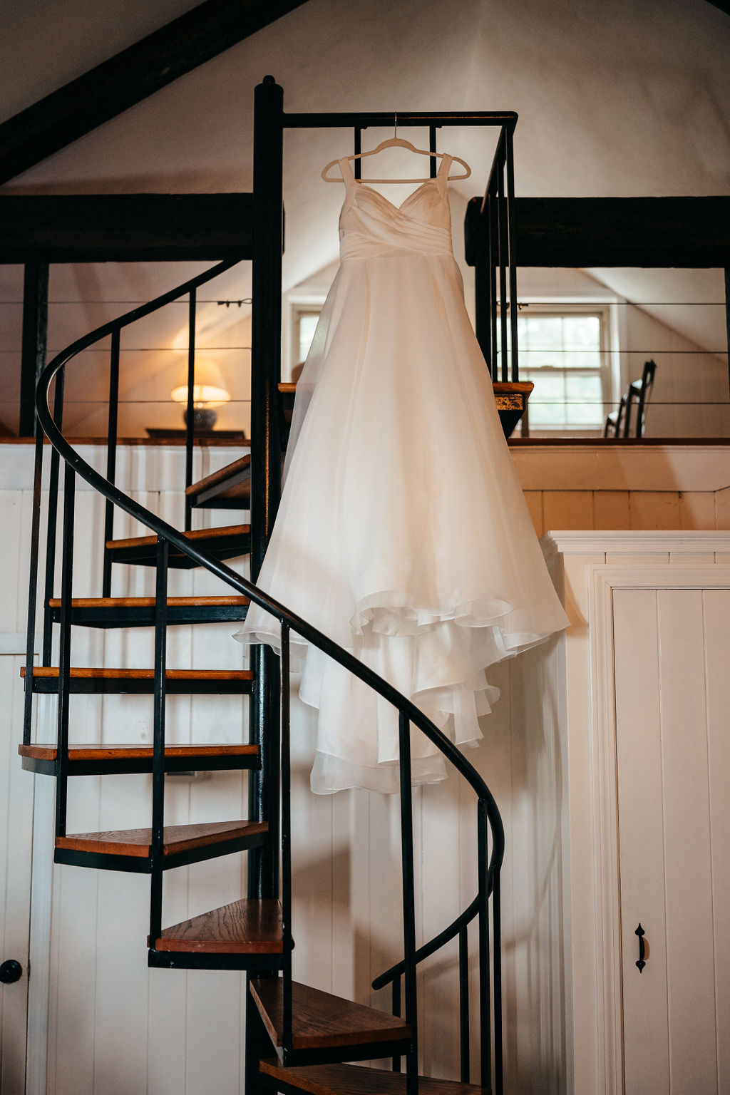 Wedding dress hanging on a staircase railing