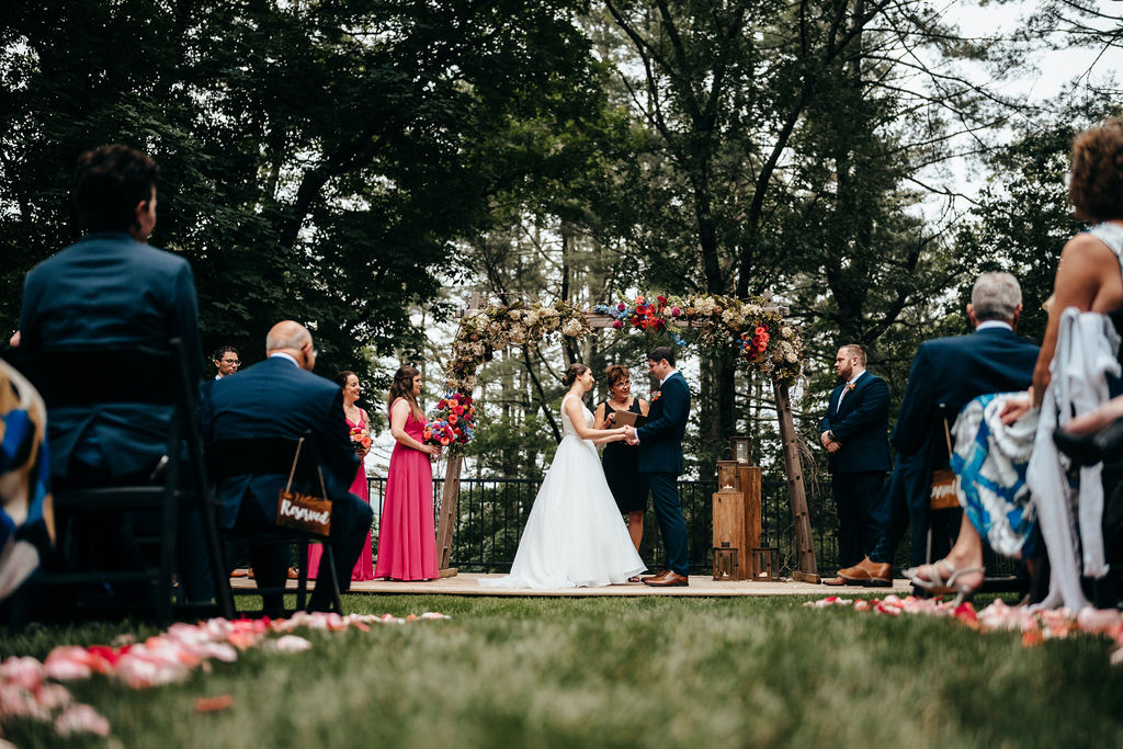 Wide view of the outdoor wedding ceremony with guests seated