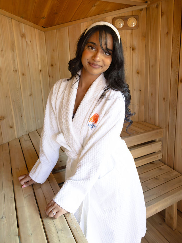 Guest relaxing in a Heat Retreat terry cloth robe inside the sauna