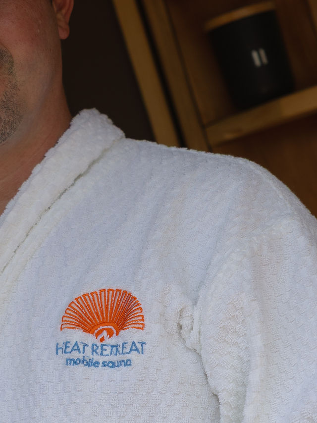 Close-up of the Heat Retreat logo embroidered on the terry cloth robe