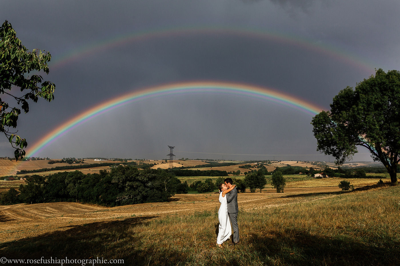 Les mariés sous un arc-en-ciel, dans la campagne
