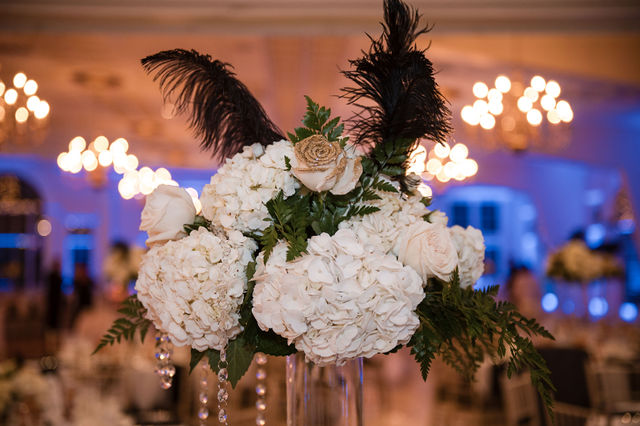 White rose centerpiece with black feathers