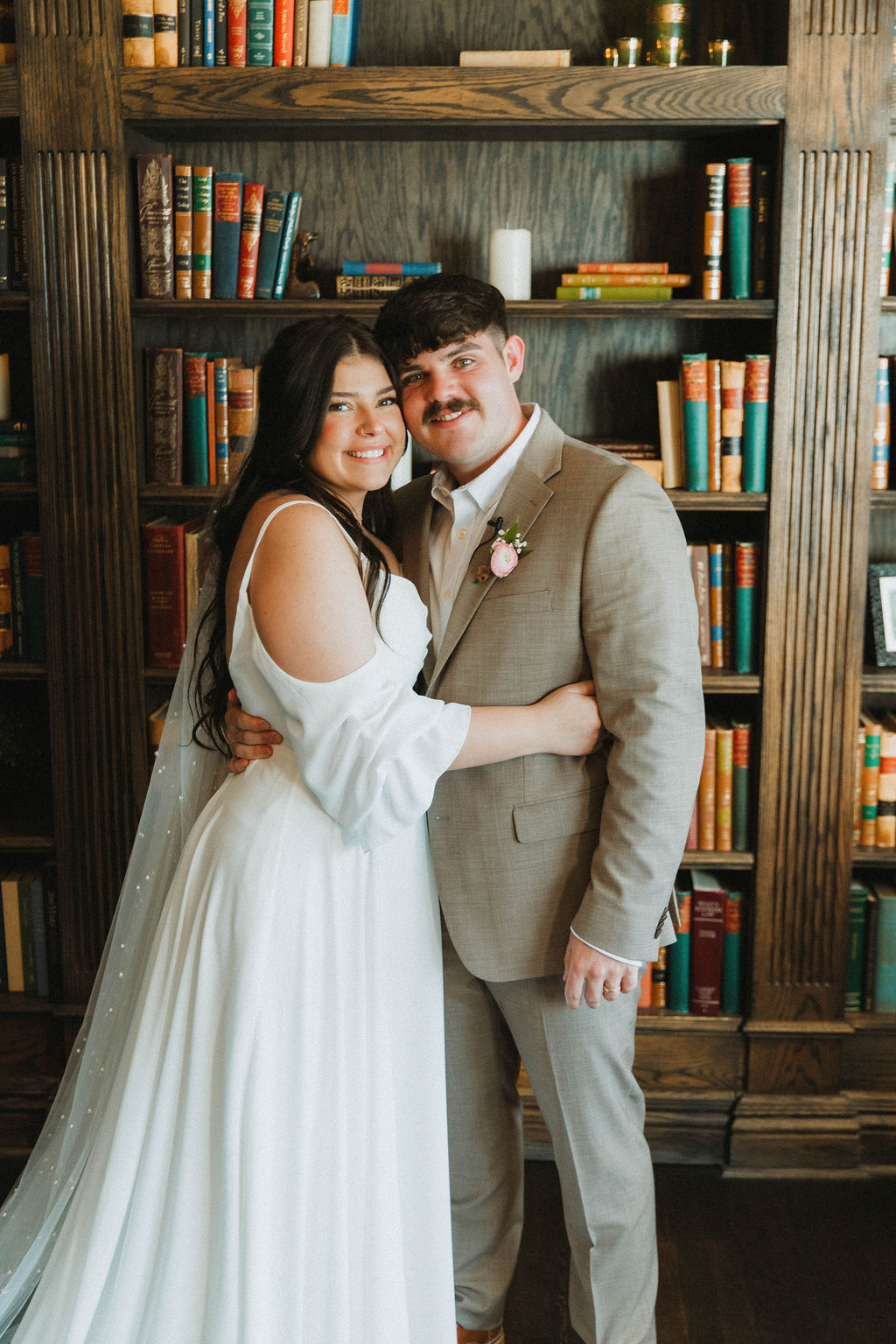 Bride and groom portrait in a wood-paneled library
