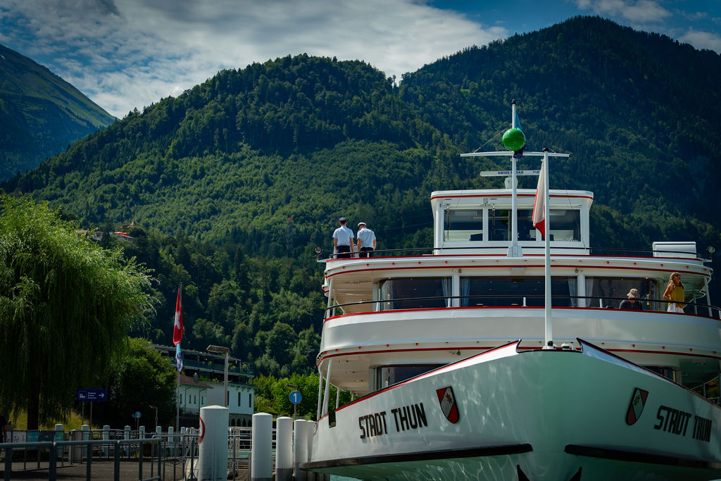 Lake steamer Stadt Thun moored below wooded mountains