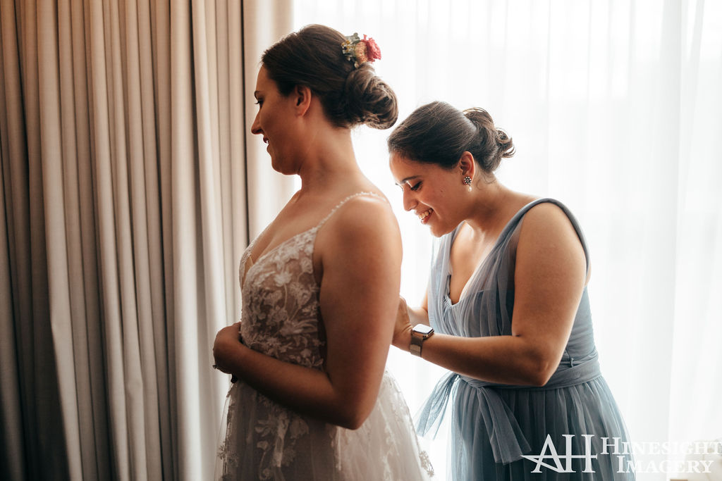 Bridesmaid helping the bride get ready