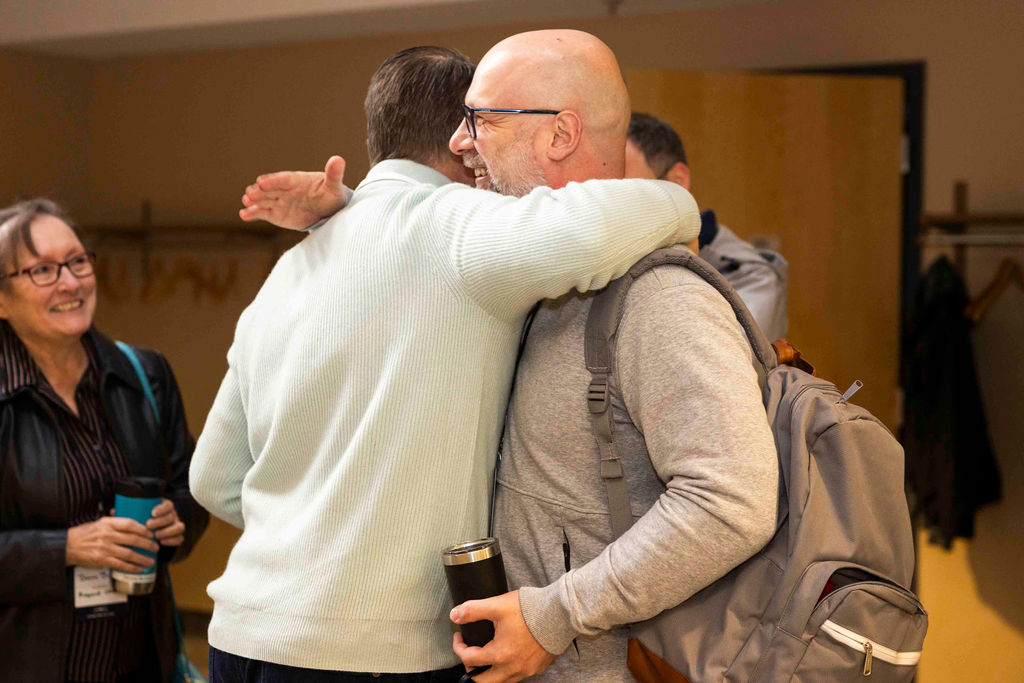 Two guests hugging hello