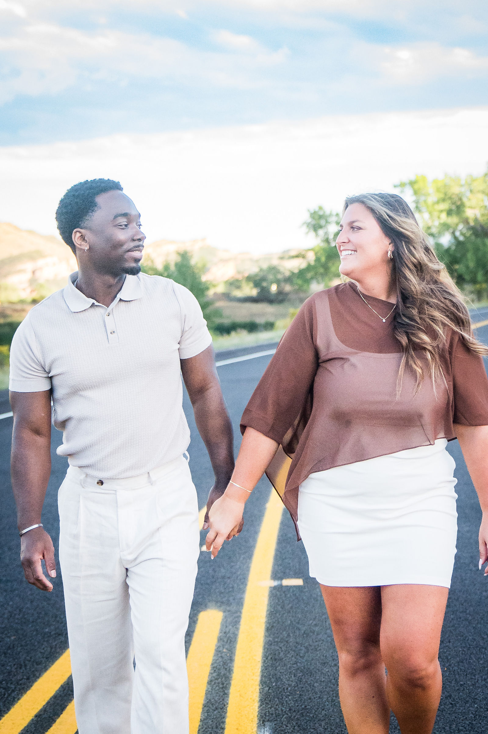 Just engaged couple walking a quiet Colorado road at golden hour