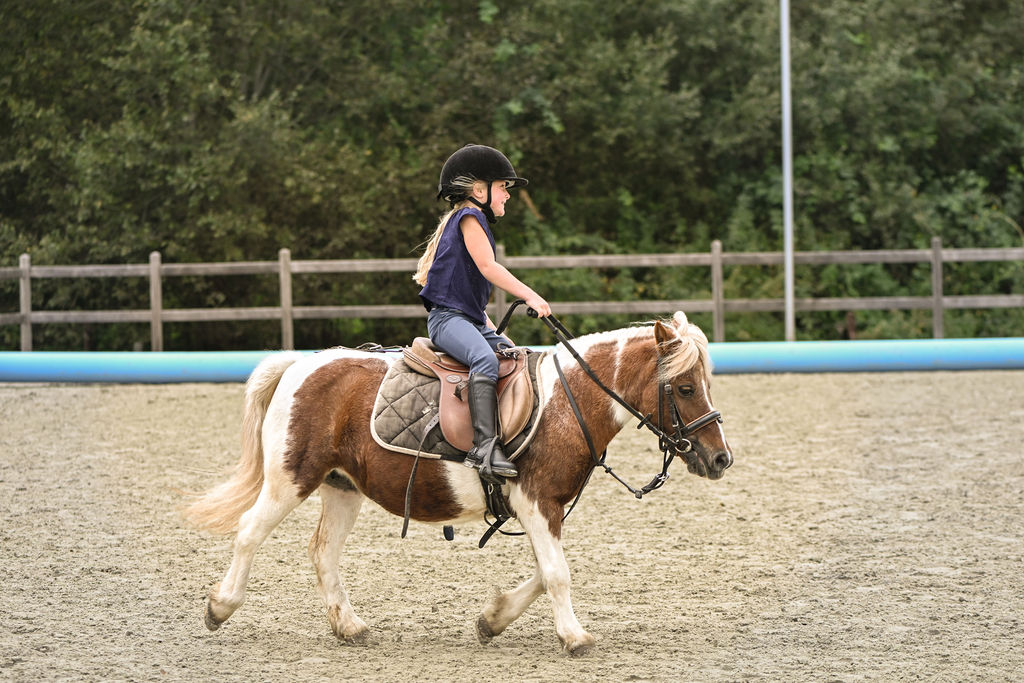 Ruiter op een pony tijdens de barrelrace op de opendeurdag