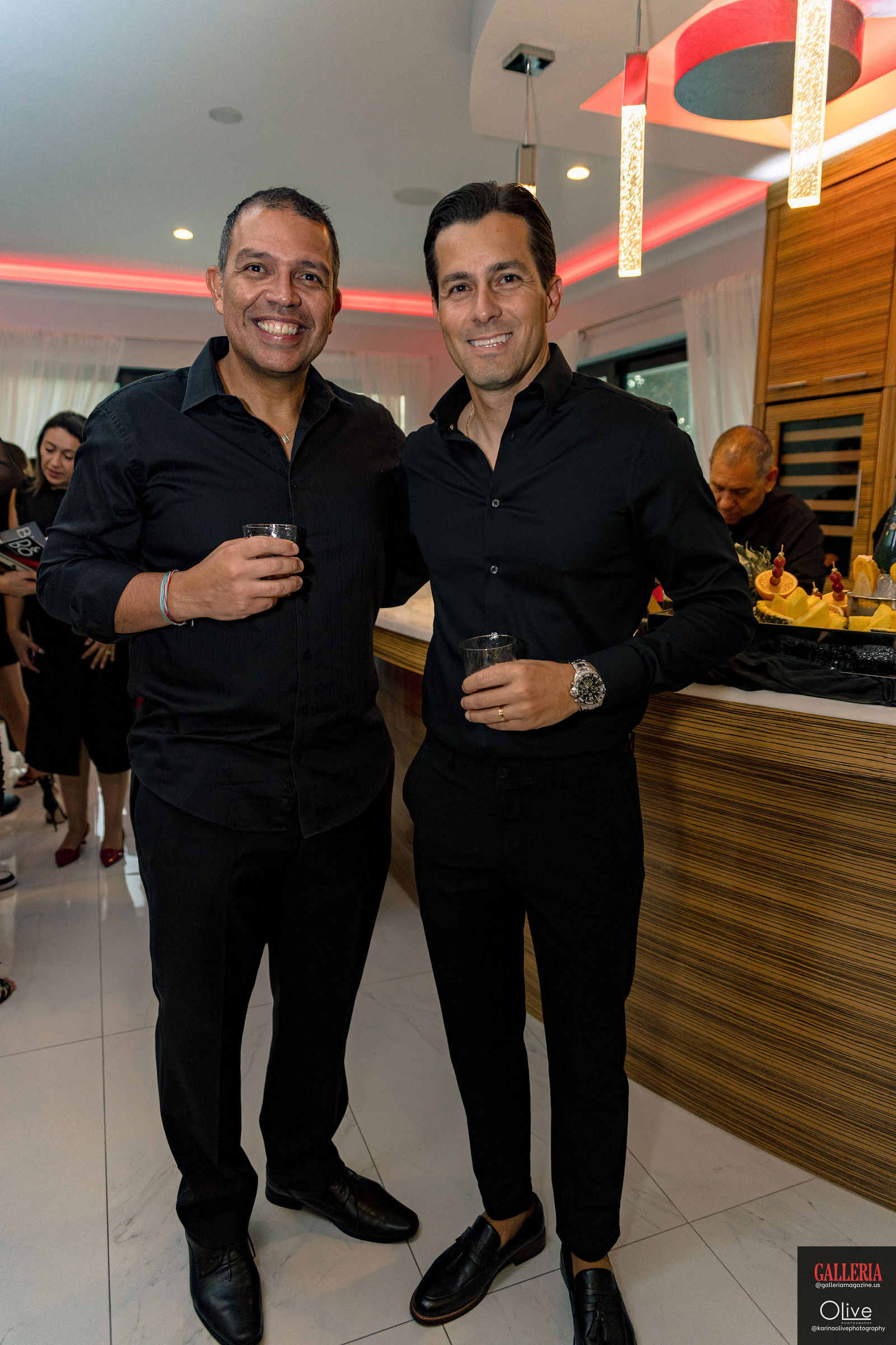 Two guests with drinks at the bar.