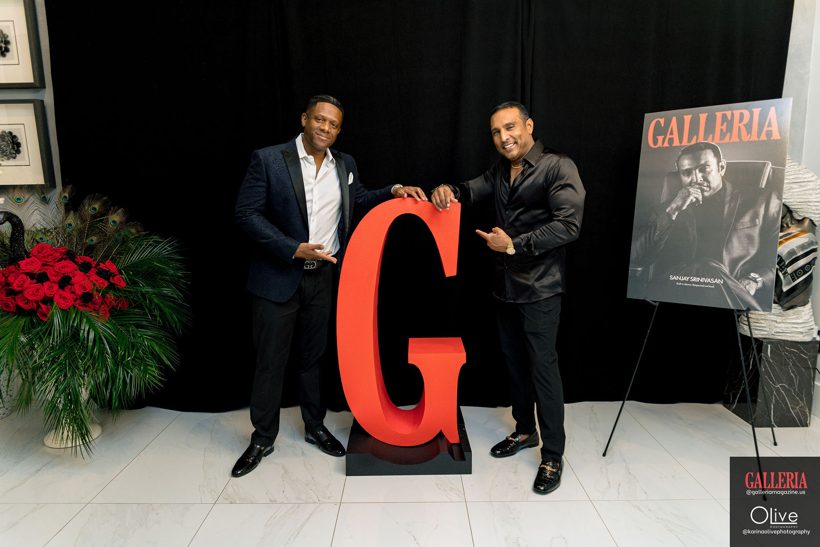 Two guests either side of the red G, the GALLERIA cover poster on an easel behind them.