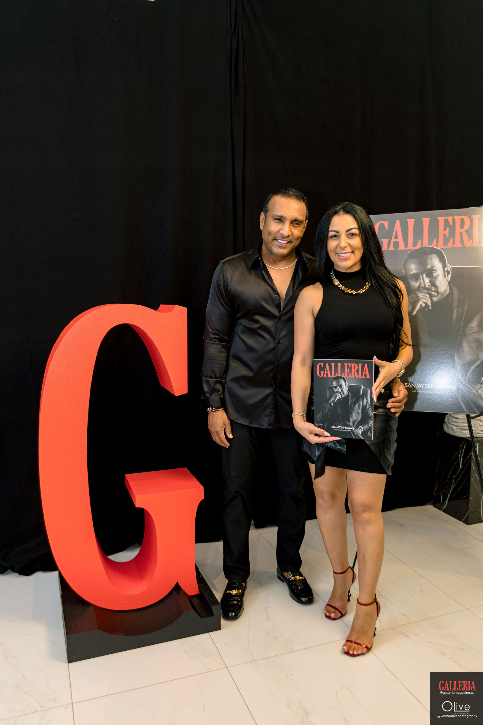 A couple posed beside the red G at the launch backdrop, the first issue held between them.