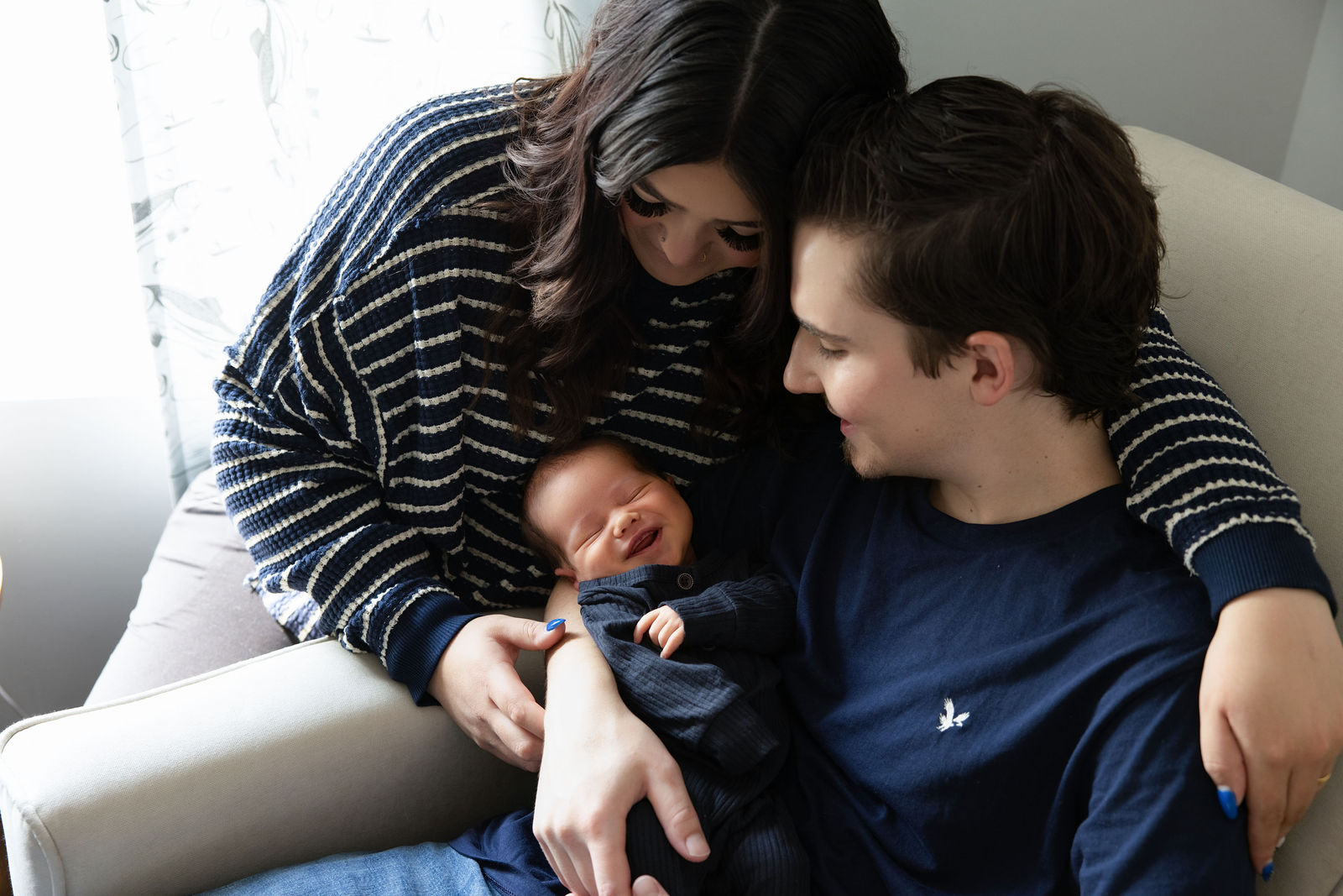 Utah County in-home newborn photography featuring parent holding baby with soft neutral tones