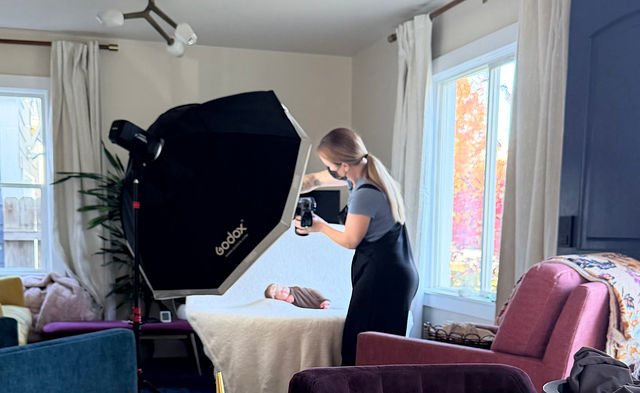 Behind the scenes lifestyle newborn photos in Utah County showing family posing near a bright window
