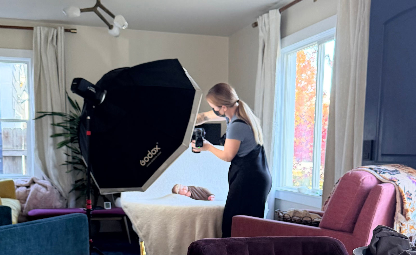 Behind the scenes of in-home newborn photography setup near window light in Salt Lake City
