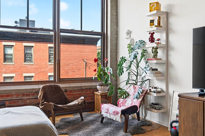 Loft sitting area with exposed brick and city window views