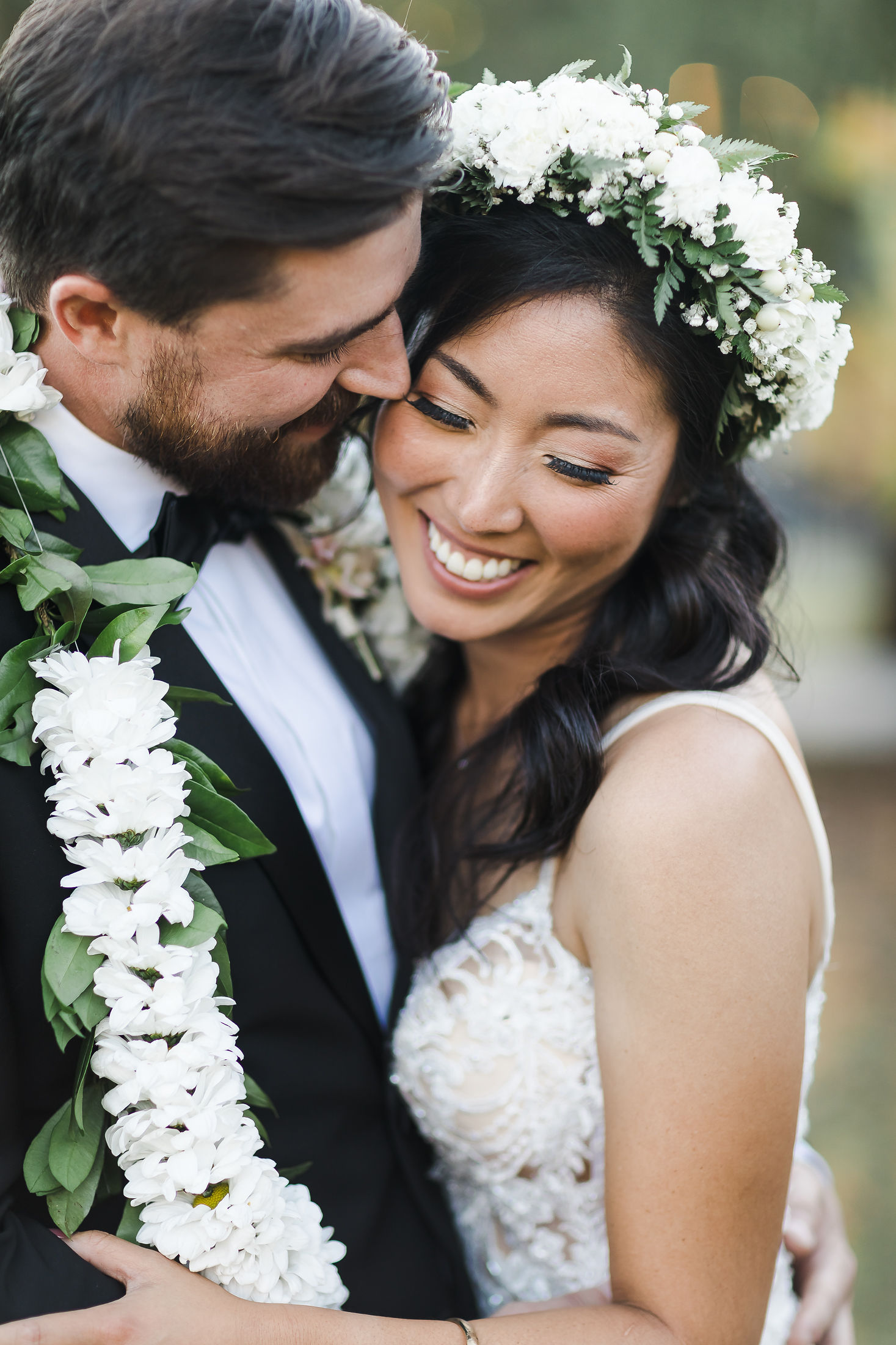 Joyful couple wearing a flower crown and lei on their wedding day in Northern California
