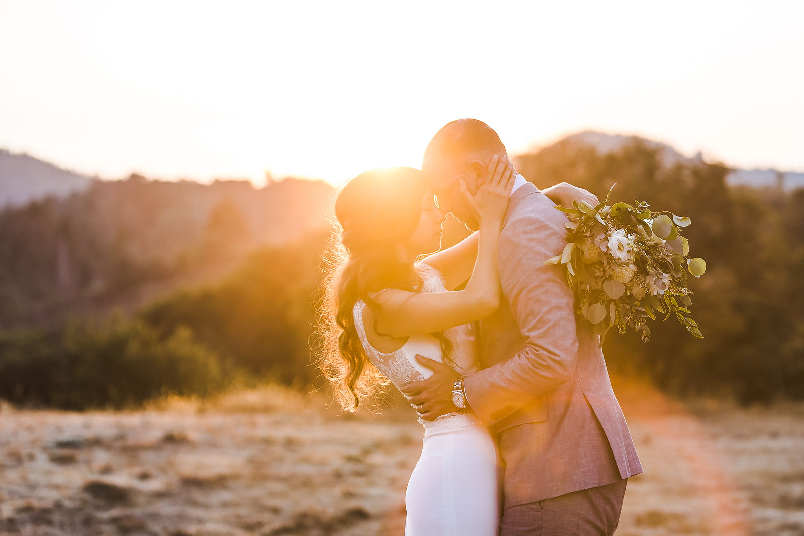 Couple embracing at golden hour above the hills, Wine Country wedding photography and film by Kreate Photography