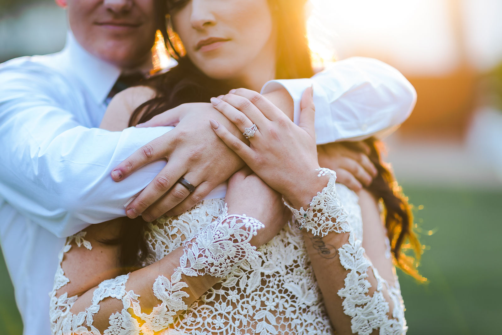 Close embrace showing lace sleeve detail in warm evening light at a Sonoma wedding