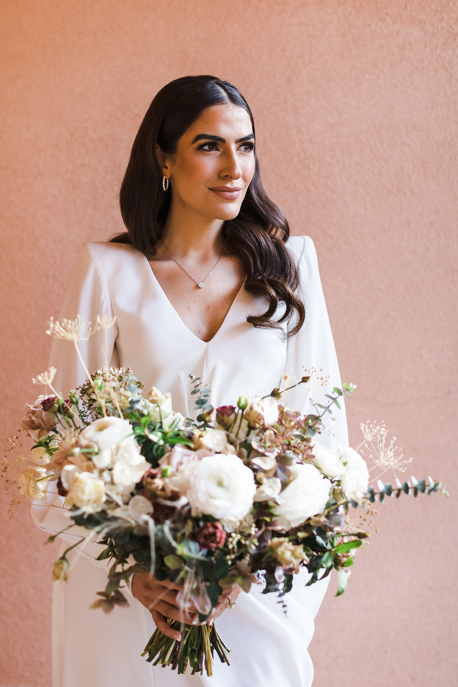 Bride holding a garden bouquet in soft window light before her Sonoma County wedding
