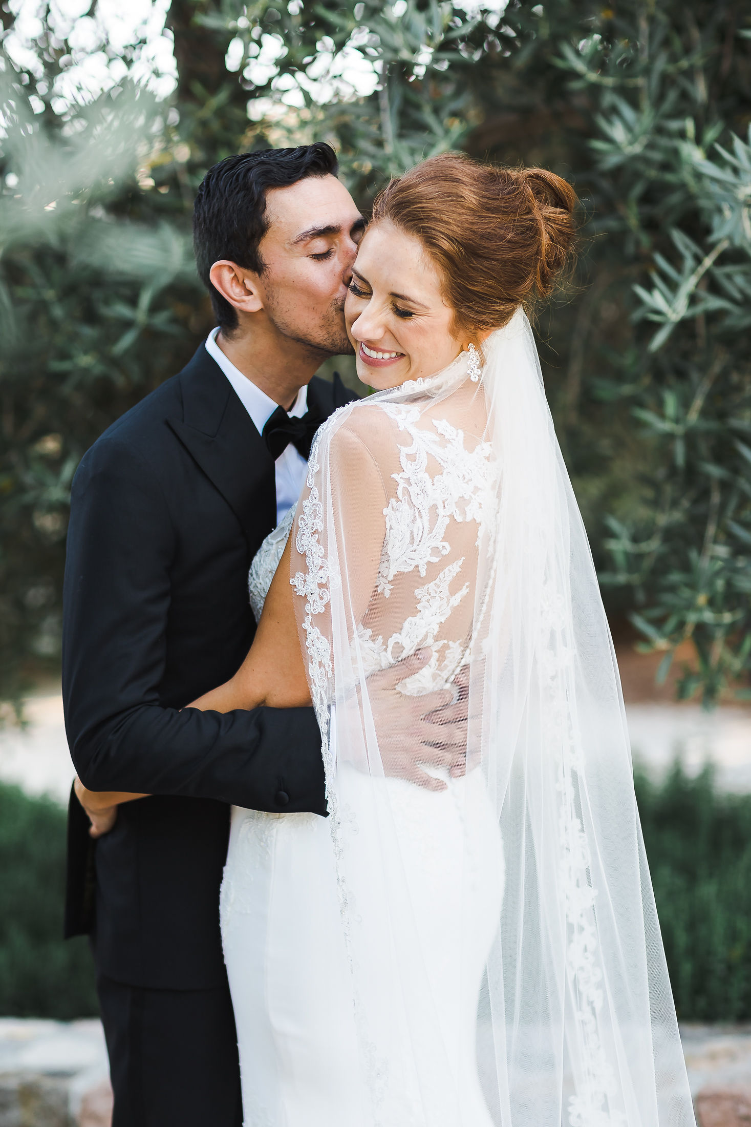 Groom kissing his bride through her veil at a Wine Country wedding