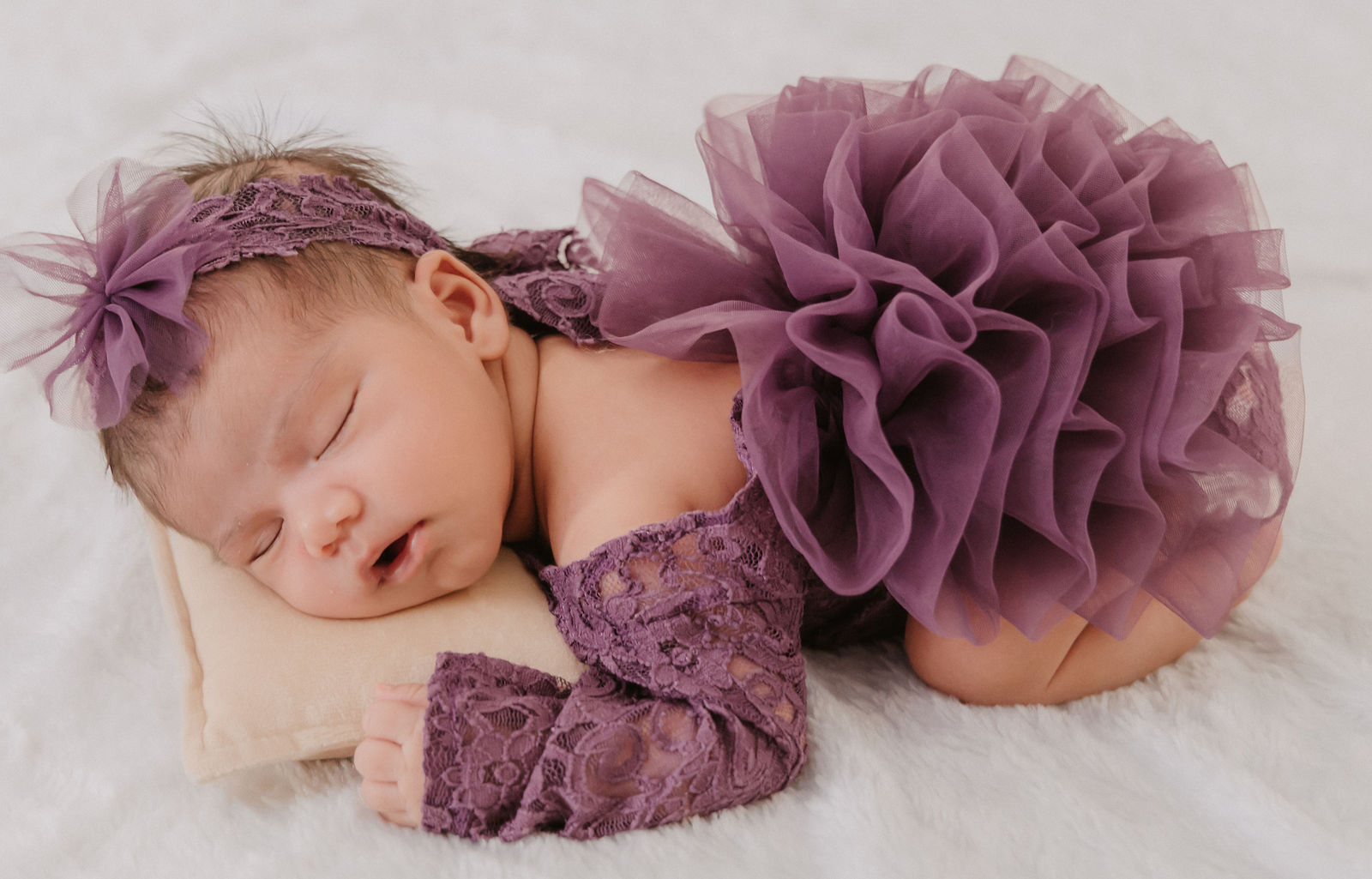 Newborn on tiny bed portrait