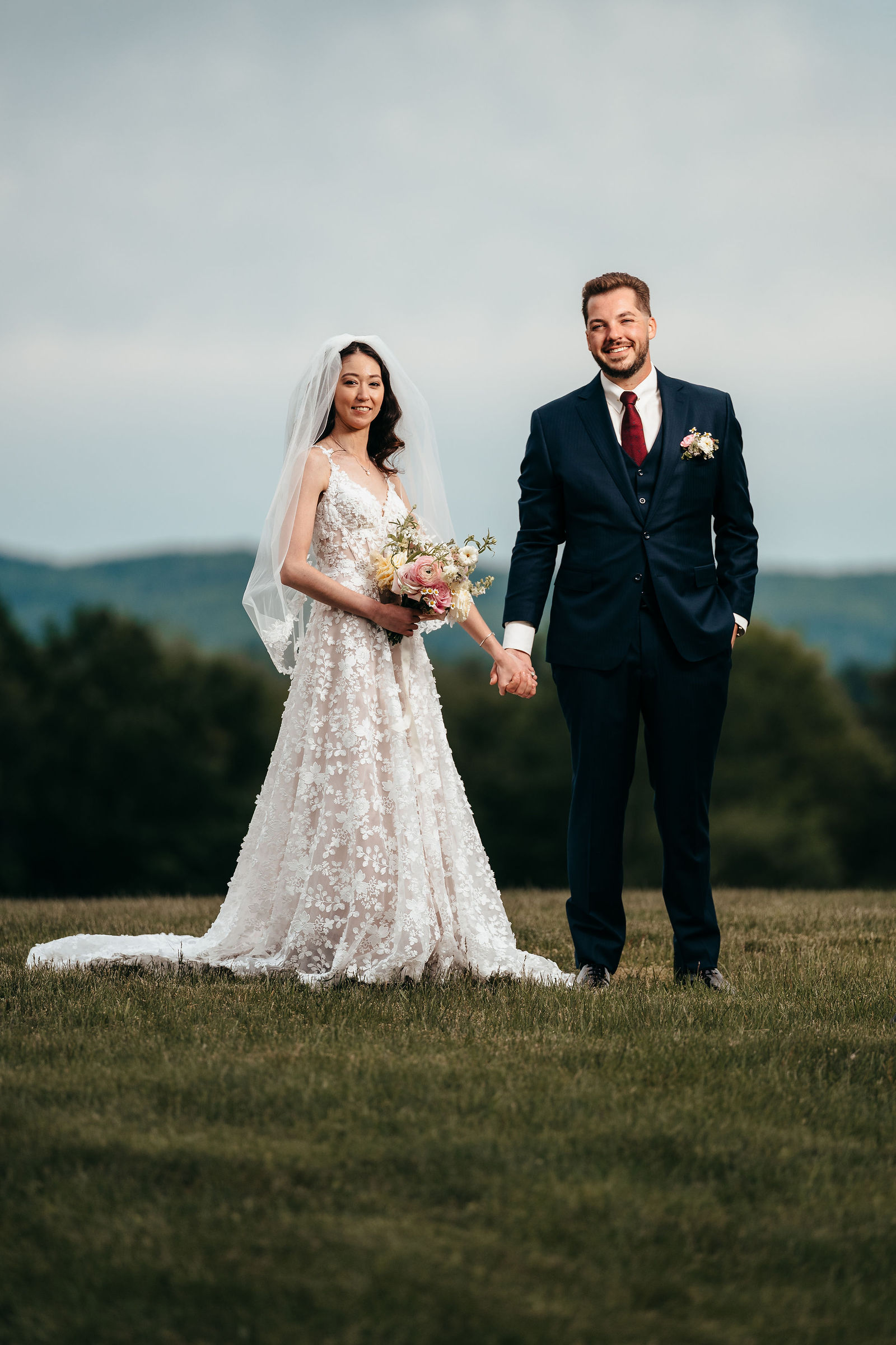 Newlyweds holding hands on the hilltop with mountain views at Dell-Lea
